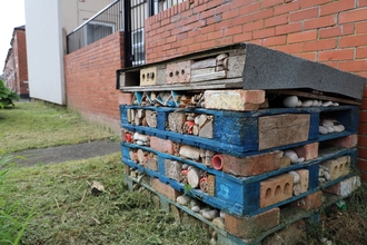 A bug hotel made of old pallet boxes, bricks and stones. 