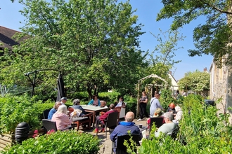 Community sitting socialising in the centre's garden. 