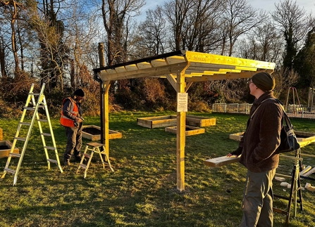 People building raised beds at a community garden