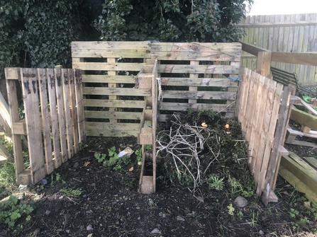 Repurposed pallets turned into a compost heap.