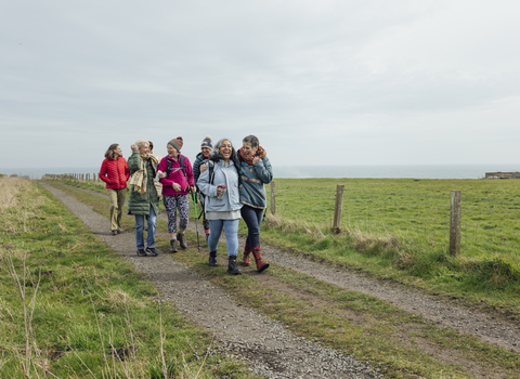 A group of women walking along a costal footpath